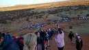 Selebaran yang diterima pada 10 Oktober 2019 memperlihatkan para wisatawan mendaki Uluru di Utara Australia.  Para pengunjung yang mengetahui rencana penutupan situs gunung batu ikonik tersebut langsung menyerbu Uluru untuk kemah dan mendaki sebelum larangan resmi diterapkan. (HO/ @koki_mel_aus/AFP)