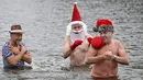 Anggota klub renang "Berliner Seehunde" (Berlin Seals) berendam di Danau Orankesee, Berlin, Minggu (25/12). Kegiatan yang sudah menjadi tradisi ini merupakan bagian dari perayaan tradisional Natal bagi warga Berlin. (Tobias SCHWARZ / AFP)