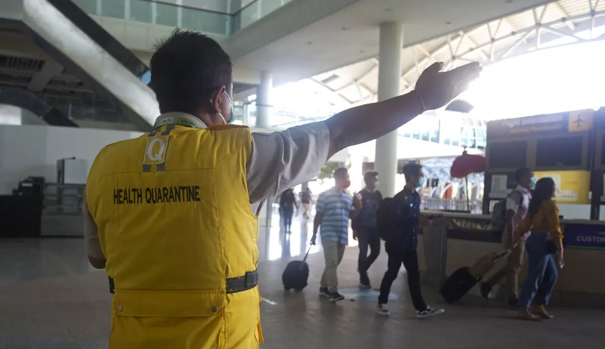 Petugas kesehatan mengarahkan penumpang tiruan ke ruang tunggu saat latihan pembukaan kembali Bandara Internasional Ngurah Rai di Bali, Sabtu (9/10/2021). Bandara Internasional Ngurah Rai akan kembali dibuka setelah ditutup lebih dari setahun karena pandemi COVID-19. (AP Photo/Firdia Lisnawati)