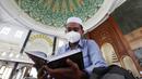 Seorang siswa mengenakan masker untuk membantu mengekang penyebaran COVID-19 saat membaca kitab suci Alquran di Masjid Attaqwa, Bekasi, Jawa Barat, Selasa (4/5/2021). Selama Ramadhan, umat muslim menahan diri dari makan, minum, merokok dan seks dari subuh hingga maghrib. (AP Photo/Achmad Ibrahim)