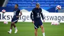Bek Prancis Jules Kounde (kiri) dan Theo Hernandez menghadiri sesi latihan di Stadion Groupama, dekat Lyon, Senin (6/9/2021). Prancis akan berhadapan dengan Finlandia dalam lanjutan Kualifikasi Piala Dunia 2022 zona Eropa Grup D, Rabu (8/9) dinihari. (FRANCK FIFE / AFP)