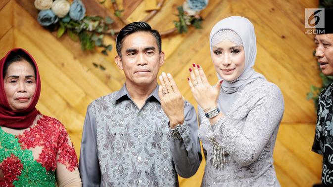Aktris Shinta Bachir bersama anggota DPRD Sidrap, Idham Masse memperlihatkan cincin saat acara lamaran di Jakarta, Sabtu (8/9). Shinta Bachir mengenakan kebaya berwarna abu-abu lengkap dengan kerudung yang menutupi kepalanya. (Liputan6.com/Faizal Fanani)
