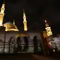 Masjid Al-Amin dan Katedral Christian Maronite saat diterangi cahaya bergambar masjid al-Aqsa dan gereja Makam Suci di Kota Tua Yerusalem di Beirut, Lebanon, (7/12). (AFP Photo/Anwar Amro)