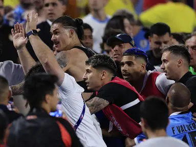 Aksi tak terpuji dilakukan para pemain Uruguay, termasuk Darwin Nunez setelah terlibat adu jotos dengan suporter Kolombia usai laga semifinal Copa America 2024 yang berkesudahan 1-0 untuk kemenangan Kolombia di Bank of America Stadium, Charlotte, Amerika Serikat, Kamis (11/7/2024) pagi WIB. Belum diketahui secara pasti siapa yang menyulut emosi lebih dulu. Namun yang pasti, Darwin Nunez dan sejumlah pemain Timnas Uruguay naik ke tribun penonton yang dipadati suporter Kolombia. (AFP/Getty Images/Buda Mendes)