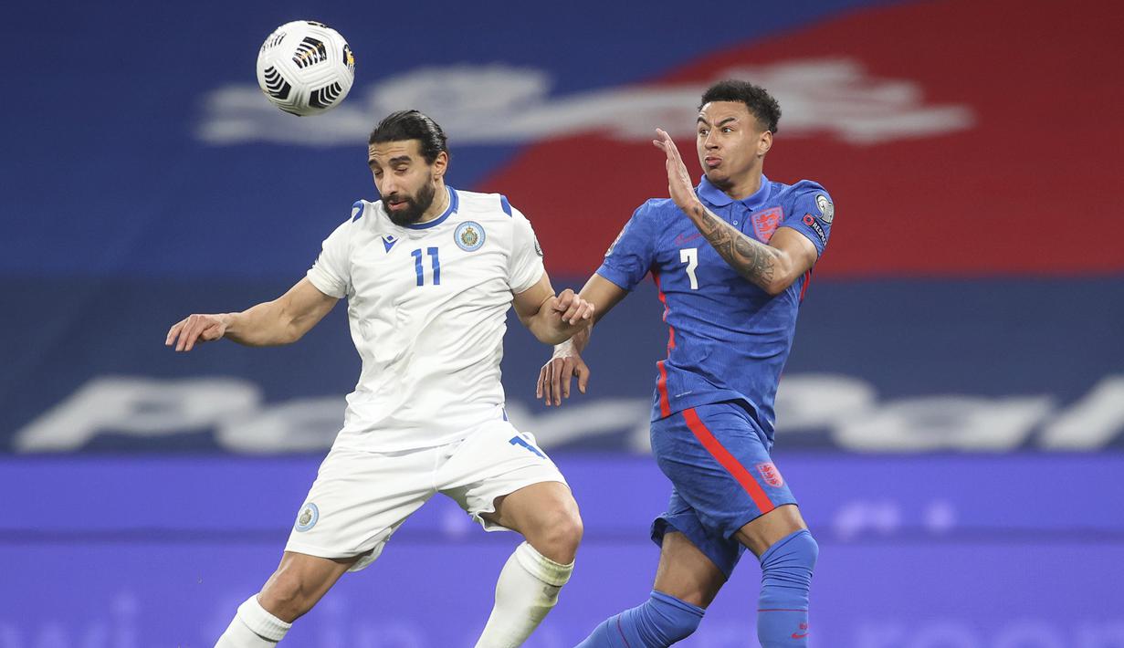 Bek San Marino, Manuel Battistini (kiri) menyundul bola di depan gelandang Inggris, Jesse Lingard dalam laga Kualifikasi Piala Dunia 2022 Zona Eropa Grup I di Wembley Stadium, London, Kamis (25/3/2021). San Marino kalah 0-5 dari Inggris. (AP/Carl Recine/Pool)