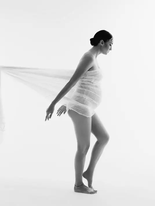 Sebelumnya, Nadine mengunggah foto versi lain dari maternity shoot ini dengan balutan kain transparan yang ditarik ke belakang.