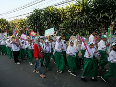 Sejumlah siswa-siswi MI/MTS Tarbiyatul Diniyah mengikuti pawai menyambut Tahun Baru Islam 1 Muharram 1445 Hijriah di Jakarta, Selasa (18/7/2023). Pawai tersebut untuk menyambut Tahun Baru Islam 1 Muharram 1445 Hijriah yang jatuh pada 19 Juli 2023 sekaligus memperkenalkan tahun Hijriah kepada pelajar. (Liputan6.com/Faizal Fanani)