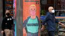 Orang-orang berjalan melewati poster yang mendorong vaksinasi di Melbourne, Australia, Kamis (30/9/2021). Melbourne bergulat dengan lonjakan infeksi Covid-19 di mana sebanyak 1.438 kasus dilaporkan, jumlah harian terbesar sejak awal pandemi. (William WEST / AFP)