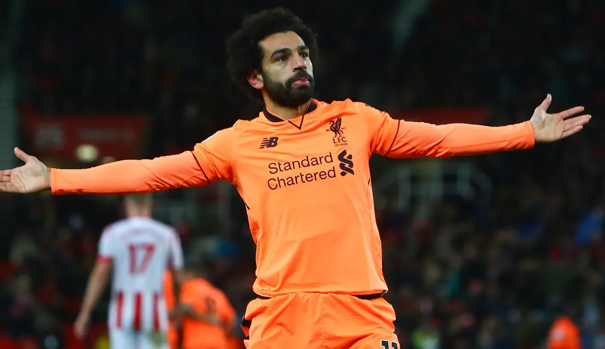 Gelandang Liverpool, Mohamed Salah berselebrasi setelah berhasil mencetak gol ke gawang Stoke City pada pekan ke-14 Premier League di Bet365 Stadium, Kamis (30/11). Dua gol Salah sukses mencukur Stoke City 3-0. (Geoff CADDICK/AFP)