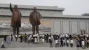 Sejumlah warga mengunjungi Mansu Hill untuk memberi penghormatan terhadap patung-patung perunggu dari Kim Il-sung dan Kim Jong-il pada peringatan 26 tahun kematian Kim Il-sung di Pyongyang, Korea Utara, Rabu (8/7/2020). (AP Photo/Jon Chol Jin)