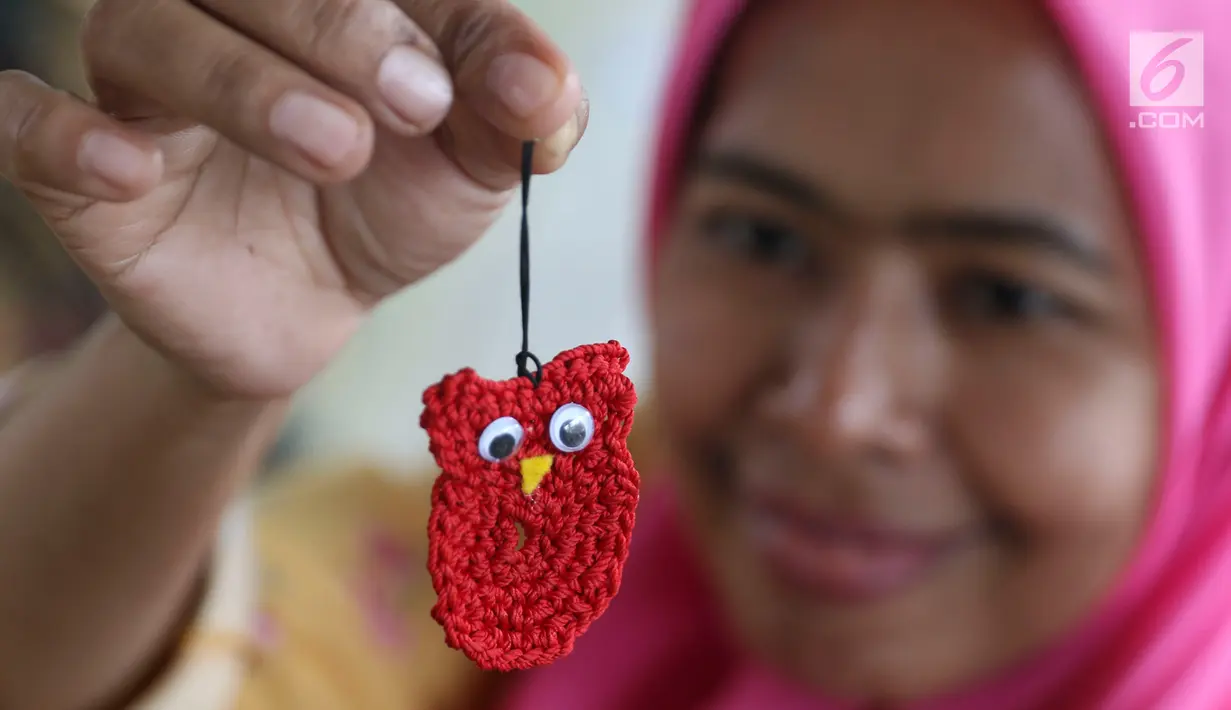 Ibu PKK menunjukkan kerajinan tangan yang dibuatnya saat pelatihan merajut di RPTRA Pademangan Timur, Jakarta, Selasa (18/12). Pelatihan digelar guna meningkatkan kemampuan dan dapat memperkuat perekonomian keluarga. (Liputan6.com/Immanuel Antonius)