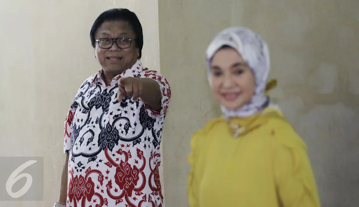 Ketua DPD RI Oesman Sapta Odang di dampingi Istri Serviati Oesman usai menggunakan hak pilihya dalam Pilkada Putaran kedua di TPS 03 Denpasar, Kuningan Timur, Jakarta, Rabu (19/4). (Liputan6.com/Johan Tallo)