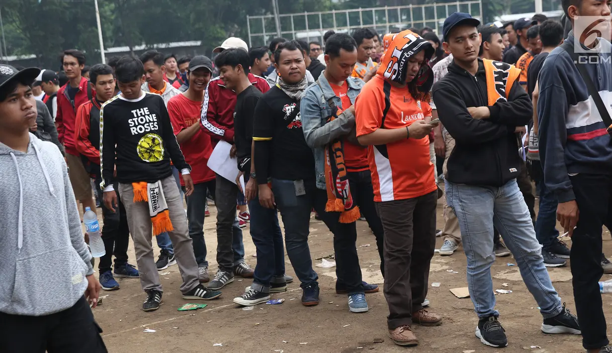 Suporter tim Persija mengantre menukarkan voucher on-line dengan tiket masuk Stadion GBK di Lapangan Blok S, Jakarta, Minggu (9/12). Mereka akan menyaksikan laga penentuan gelar juara Persija di Liga 1 Indonesia 2018. (Liputan6.com/Helmi Fithriansyah)