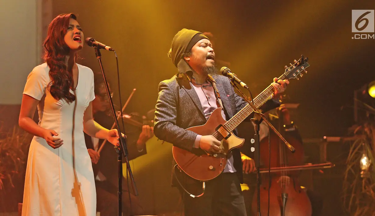 Penyanyi Monita Tahalea duet bersama vokalis Payung Teduh, Is saat tampil dalam konser BBM x Liztomania vol.3 di Gedung Kesenian Jakarta, Selasa (14/11). (Liputan6.com/Herman Zakharia)