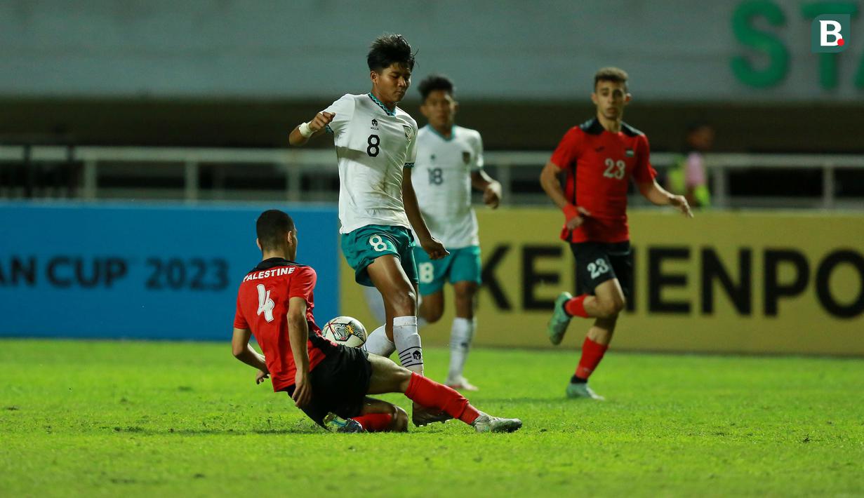 <p>Pemain Timnas Indonesia U-17, Arkhan Kaka berusaha melewati pemain Palestina, Ibrahim Alfuqaha pada laga Grup B Kualifikasi Piala Asia U-17 2023 antara Timnas Indonesia menghadapi Palestina di Stadion Pakansari, Bogor, Jumat (7/10/2022). (Bola.com/M Iqbal Ichsan)</p>