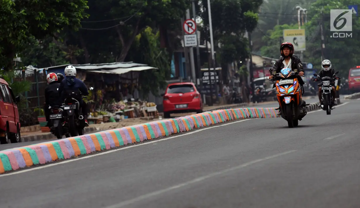 Pengendara melintasi Jalan TB Simatupang, Jakarta, Jumat (7/7). Jalan TB Simatupang sekitar perempatan Pasar Rebo menjadi berwarna dengan tampilan pot cat dan pembatas jalan warna warni. (Liputan6.com/Helmi Fithriansyah)