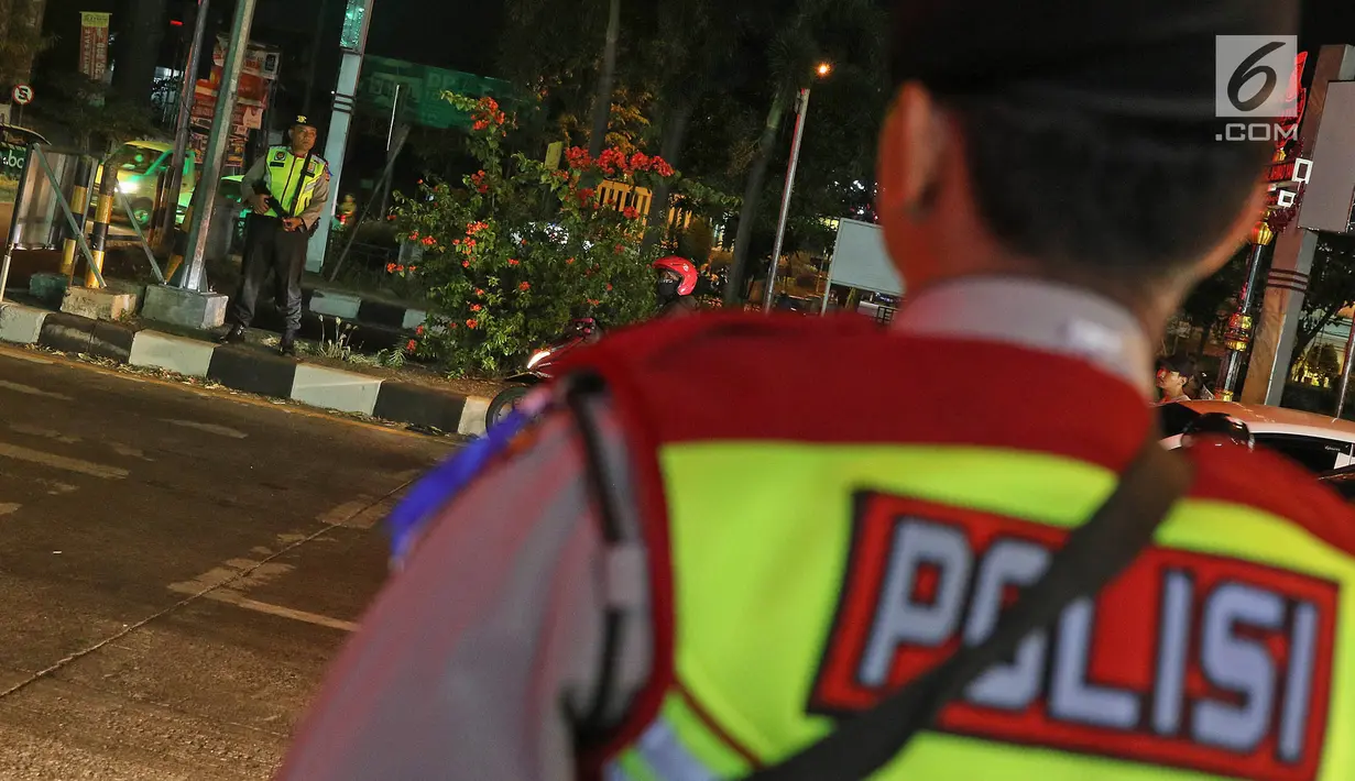 Polisi bersenjata berjaga di pos pelayanan terpadu Operasi Ketupat Lodaya 2019, Jalan Raya Pantura, Cirebon, Jawa Barat, Sabtu (1/6/2019). Objek pengamanan dalam Operasi Ketupat Tahun 2019 antara lain terminal, objek wisata, pelabuhan, stasiun kereta api, dan bandara. (Liputan6.com/Herman Zakharia)