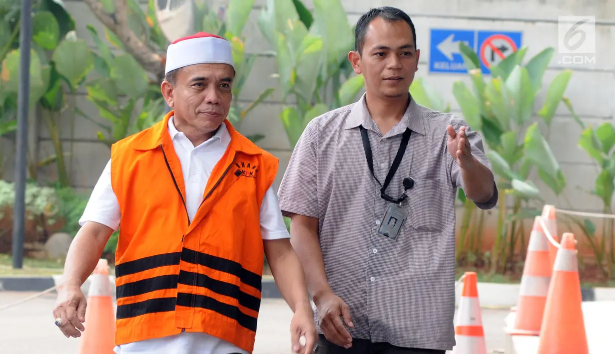 Gubernur Aceh Irwandi Yusuf memakai rompi oranye dikawal petugas saat tiba untuk turun dari mobil tahanan tiba untuk menjalani pemeriksaan lanjutan di gedung KPK, Jakarta, Rabu (25/7). (Merdeka.com/Dwi Narwoko)