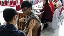 Seorang mahasiswa saat disuntik vaksin difteri di Universitas Tarumanegara, Jakarta, Kamis (14/5). Ratusan mahasiswa/wi yang berusia di bawah 19 tahun mendapatkan imunisasi (Td) sebagai antisipasi mewabahnya penyakit difteri. (Liputan6.com/Faizal Fanani)