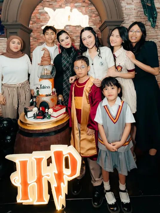 Di sebelah Rachel, sang ibu, Vien Tasman, juga ikut memeriahkan acara dengan mengenakan jubah hitam panjang ala penyihir Hogwarts. Ia tampil elegan dengan paduan syal kotak-kotak khas sekolah sihir, menambah sentuhan magis pada penampilannya. [@vienstasman]