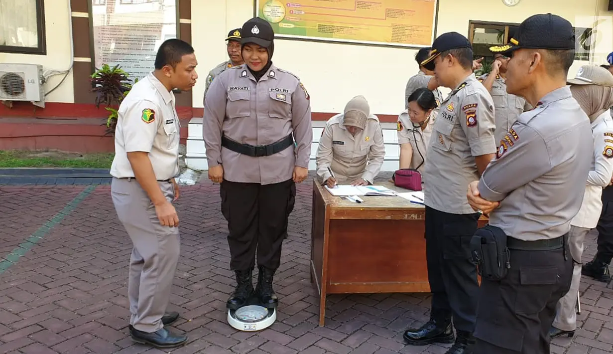 Polwan saat diukur berat badan usai apel pagi di lapangan apel Mapolda Gorontalo, Senin (13/5/2019). Para personil diberi target harus mampu menurunkan berat badan selama Ramadan. Selanjutnya akan dilakukan pengukuran atau penimbangan kembali. (Liputan6.com/Arfandi Ibrahim)
