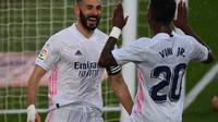 Striker Real Madrid, Karim Benzema (kiri) merayakan gol yang dicetaknya ke gawang Eibar dalam lanjutan Liga Spanyol, Sabtu (3/4/2021). (GABRIEL BOUYS / AFP)