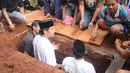 Sebelum jenazah diurug dengan tanah, suami Ririn Ekawati itu tampak melantunkan iqomah. [Foto: Adrian Putra/Fimela.com]