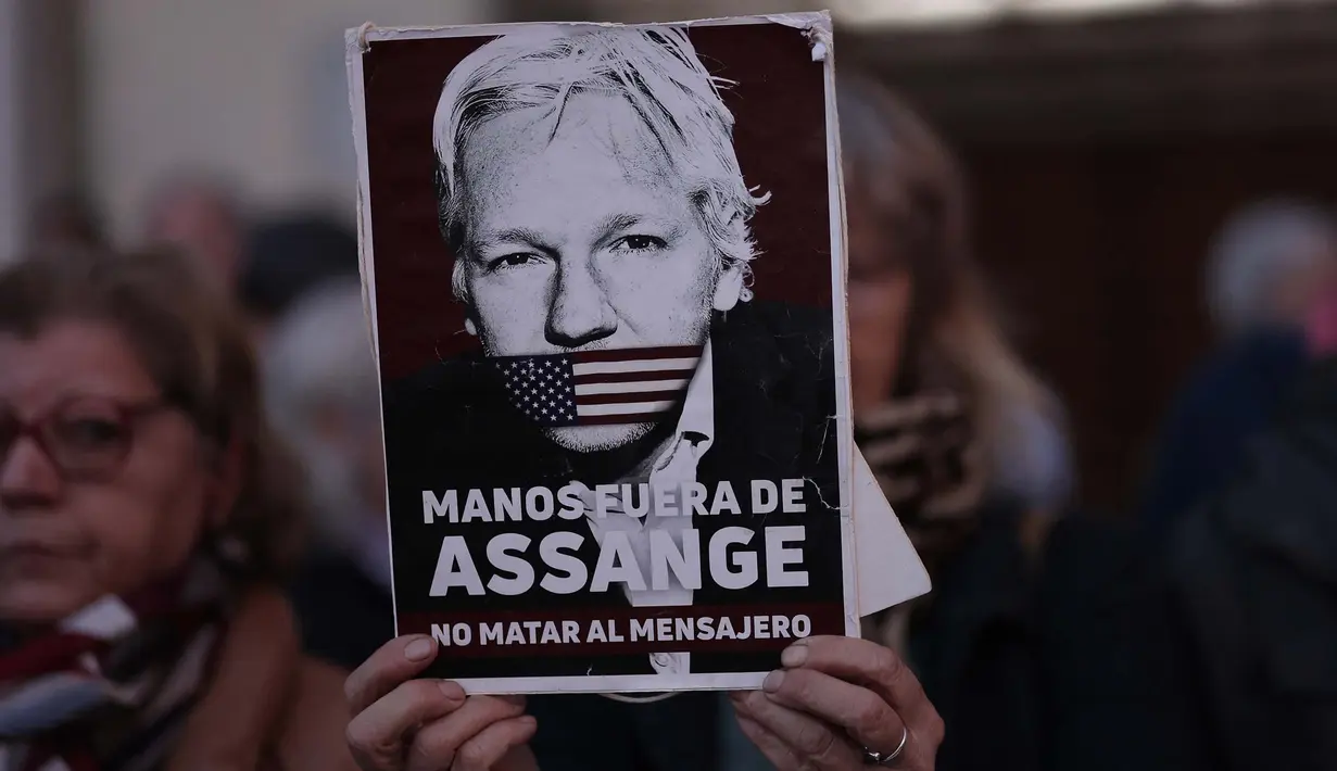 Seorang pengunjuk rasa memegang tanda bertuliskan "Hands off Assange, don't kill the messenger" dalam sebuah unjuk rasa untuk mendukung pendiri Wikileaks Julian Assange, di depan kedutaan besar Amerika Serikat (AS) di Madrid, pada tanggal 20 Februari 2024. (Thomas COEX/AFP)