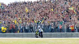 Pembalap tim Movistar Yamaha MotoGP Valentino Rossi merayakan kemenangannya setelah memenangkan Grand Prix di Sirkuit TT di Assen pada 27 Juni 2015. Rossi akan menyelesaikan musim 2021 dan kemudian mundur dari balapan yang membesarkan namanya. (AFP/Bas Czerwinski/ANP)