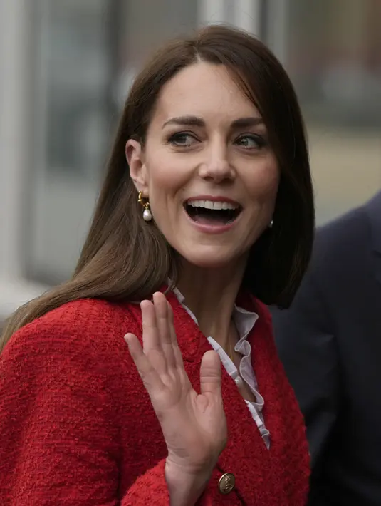 Kate Middleton, Duchess of Cambridge, melambaikan tangan saat tiba di Universitas Kopenhagen, Denmark (22/2/2022). Kate, Duchess of Cambridge tampil berpakaian diplomatis dengan blazer Zara merah dan blus putih berkerut. (AP Photo/Alastair Grant)