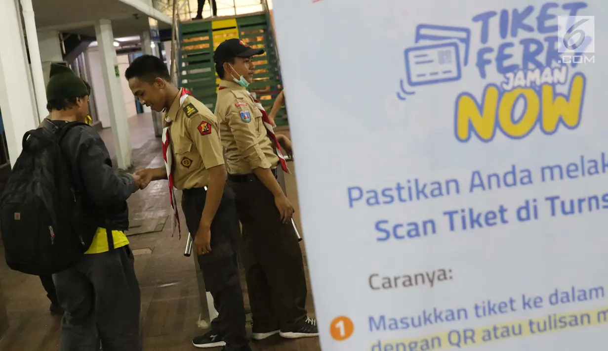 Anggota Pramuka membantu calon penumpang melakukan cek in elektronik di ruang tunggu menuju dermaga Pelabuhan Penyeberangan Merak, Banten, Sabtu (1/6/2019). Hingga Sabtu (1/6) pukul 08.00 WIB, tercatat 400.309 orang menyebrang dari pelabuhan Merak menuju Bakauheni. (Liputan6.com/Helmi Fithriansyah)