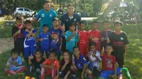 Kiper Arema, Joko Ribowo (kanan), bersama anak-anak dari JRFA di Pati, Jawa Tengah. (Bola.com/Iwan Setiawan)