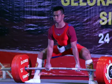 Lifter Lampung, Viky Aryanto saat akan mengangkat beban seberat 291kg di kelas 66 kg putra PON XIX di GOR Sabilulungan, Kab Bandung, Minggu (25/9). Viky merebut emas di kelas 66 kg dengan total angkatan 798 kg. (Liputan6.com/Helmi Fithriansyah)