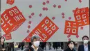 Pejalan kaki berjalan di depan toko Uniqlo yang dioperasikan oleh Fast Retailing Jepang di Tokyo, Rabu (11/1/2023). Fast Retailing, yang mengoperasikan lebih dari 3.500 toko pakaian di seluruh dunia, mengatakan sistem remunerasinya akan direvisi mulai Maret, dan level di Jepang akan dinaikkan secara signifikan. (Philip FONG / AFP)