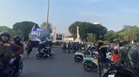 Warga yang melintas di depan Istana Merdeka, Jakarta tampak antusias menyaksikan upacara penurunan bendera merah putih di IKN lewat layar raksasa. (Liputan6.com/Muhammad Radityo Priyasmoro)