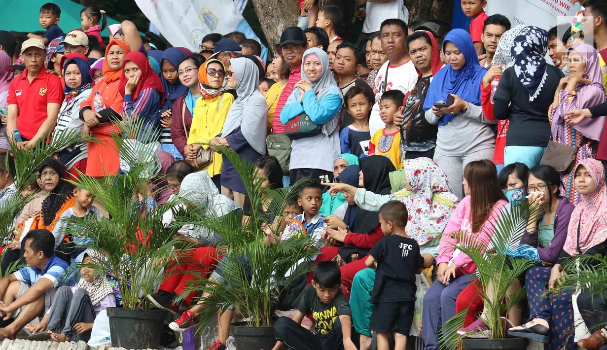 Warga menyaksikan pertandingan antara Menteri KKP Susi Pudjiastuti dan Wagub DKI Jakarta Sandiaga Uno mengarungi danau sunter selama Festival Danau Sunter di Jakarta, Minggu (25/2). (Liputan6.com/Angga Yuniar)