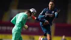 Kiper Burnley, Nick Pope menanduk bola dari ancaman striker Arsenal, Pierre-Emerick Aubameyang dalam laga lanjutan Liga Inggris 2020/21 di Turf Moor, Burnley, Sabtu (6/3/2021). Burnley bermain imbang 1-1 dengan Arsenal. (AFP/Jon Super/Pool)