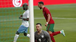 Gelandang Portugal, Bruno Fernandes (kanan) melakukan selebrasi usai mencetak gol pertama Portugal ke gawang Israel dalam laga uji coba menjelang Euro 2020 di Jose Alvalade Stadium, Lisbon, Rabu (9/6/2021). Portugal menang 4-0 atas Israel. (AP/Armando Franca)