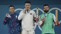 Para peraih medali kelas 73 kg putra cabor angkat besi Olimpiade Paris 2024 (dari kiri) Weeraphon Wichuma (perak/Thailand), Rizki Juniansyah (emas/Indonesia) dan Dimitrov Bozhidar Andreev (perunggu/Bulgaria) berfoto di atas podium usai upacara penyerahan medali di Paris Expo Porte de Versailles, Paris, Kamis (8/8/2024). (AP Photo/Kin Cheung)