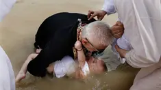 Imam Kristen Ortodoks Serbia membaptis seorang bayi di perairan Sungai Yordan di dekat kota Jericho (4/3). Di tempat ini diyakini Yesus Kristus dibaptis oleh Yohanes Pembaptis. (AFP Photo/Gali Tibbon)
