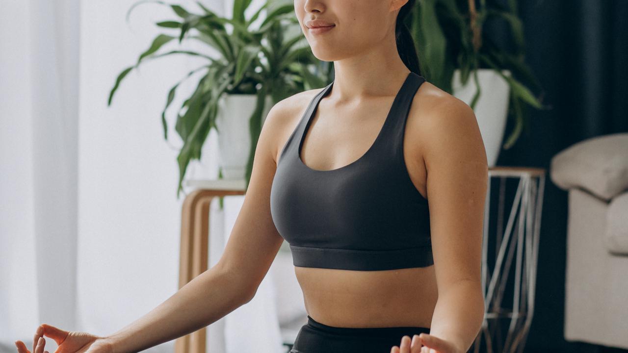 Seorang perempuan sedang melakukan meditasi di rumahnya (Foto Dok: Freepik/senivpetro)