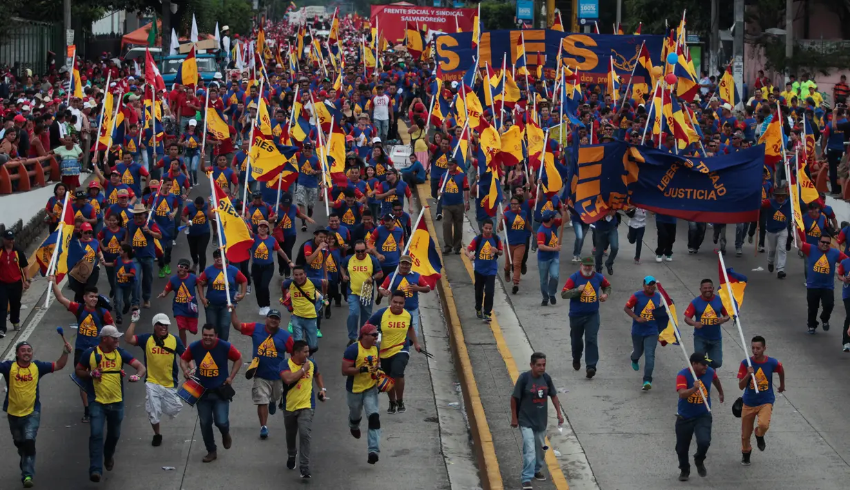 Sejumlah orang ikut pawai dalam peringatan May Day 2016 atau Hari Buruh Sedunia di San Salvador, El Salvador, Minggu (1/5). Di beberapa negara, peringatan buruh sempat diwarnai dengan aksi bentrok.  (REUTERS/Jose Cabezas)