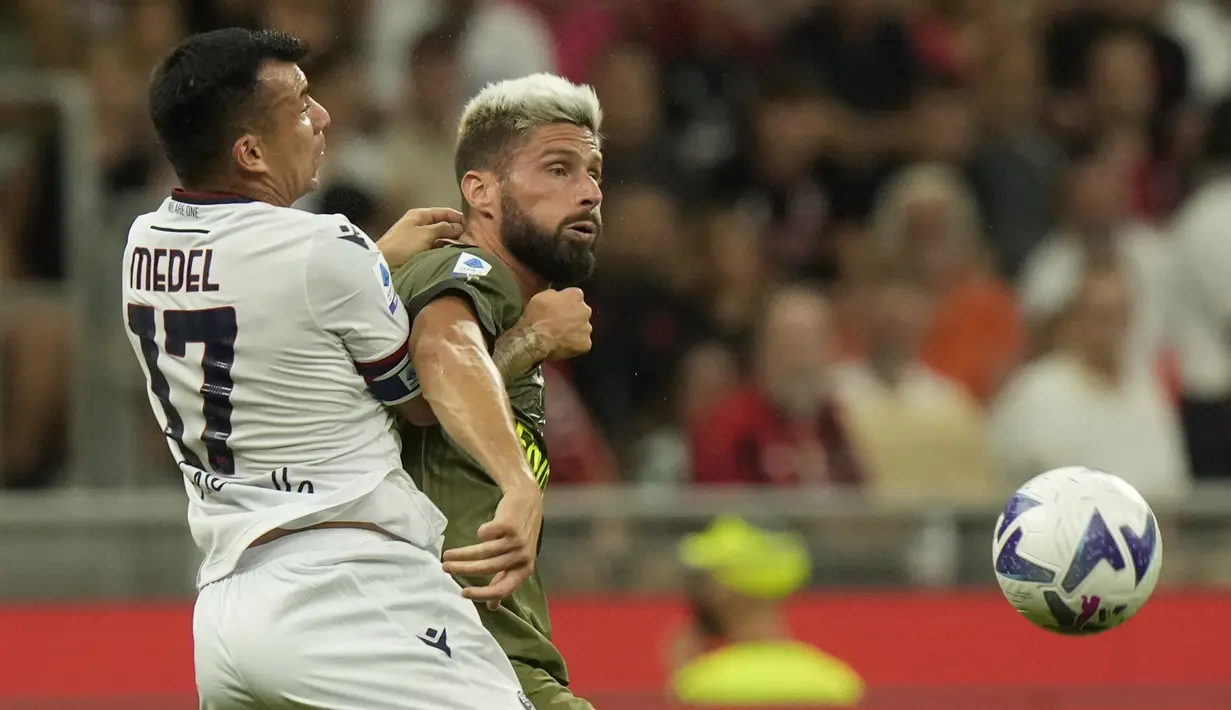 Penyerang AC Milan Olivier Giroud berebut bola dengan bek Bologna Gary Medel dalam laga giornata ke-3 Liga Italia di San Siro, Minggu dini hari WIB (28/8/2022). LAC Milan sukses mengalahkan Bologna 2-0 dengan gol-gol kemenangan skuad asuhan Stefano Pioli dibukukan Rafael Leao dan Olivier Giroud. (AP Photo/Luca Bruno)