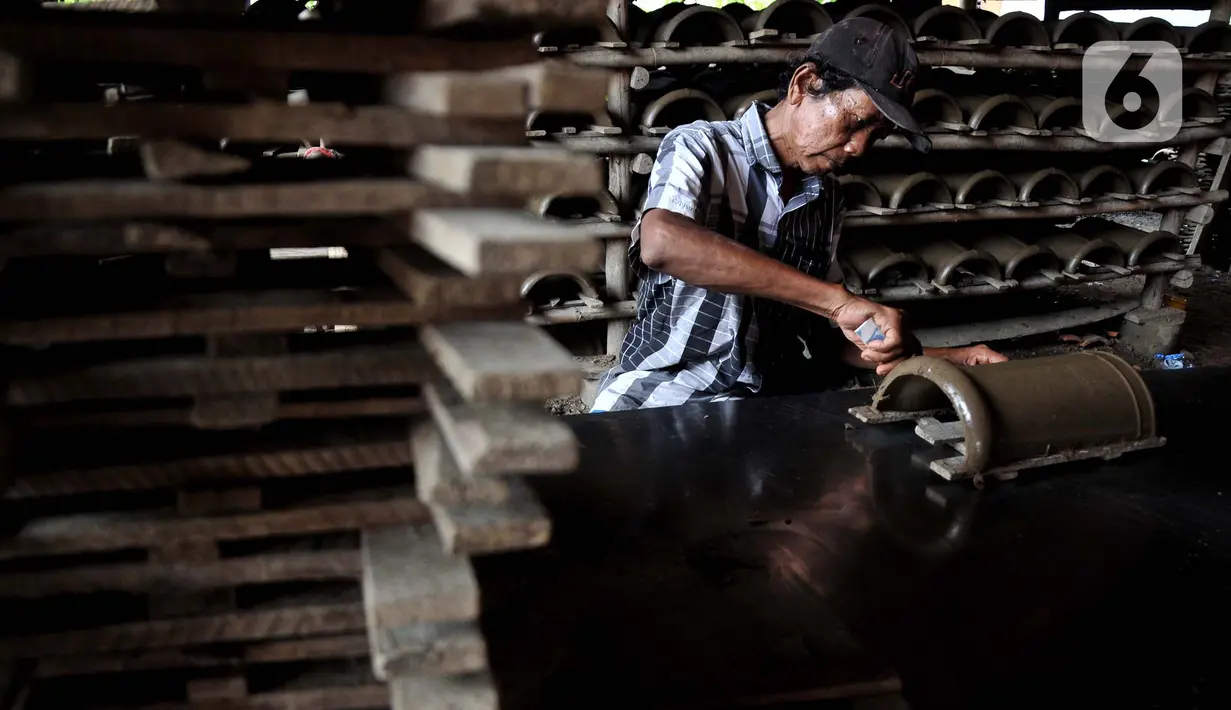 Pekerja memotong genteng sebelum dijemur di pabrik genteng rumahan (Jebor) Mutiara Putra, Desa Burujul Wetan, Kecamatan Jatiwangi, Kabupaten Majalengka, Minggu (30/1/2022).  Akibat ekspansi pasar genteng pabrikan modern sebagian besar warga beralih profesi. (merdeka.com/Iqbal S. Nugroho)