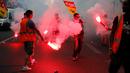 Pekerja kereta api memegang flare saat melakukan demonstrasi di Paris, Prancis (23/5). Mereka memprotes kebijakan pemerintah terkait pemangkasan 120.000 pekerjaan pada 2022. (AP/Francois Mori)