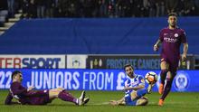 Striker Wigan Athletic, Will Grigg mencetak gol ke gawang Manchester City pada babak kelima Piala FA di DW Stadium, Senin (19/2). Manchester City City disingkirkan oleh tim divisi ketiga Wigan Athletic dengan skor 1-0. (Oli SCARFF / AFP)