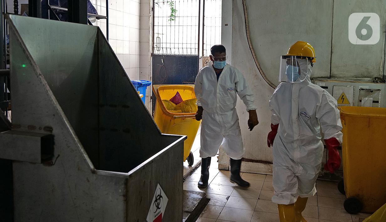 Petugas bersiap melakukan proses pembakaran limbah medis dalam incinerator di RSCM Jakarta, Jumat (26/6/2020). Menteri Lingkungan Hidup, Siti Nurbaya Bakar menyebutkan volume limbah medis infeksius di seluruh Indonesia hingga 8 Juni 2020 mencapai lebih dari 1.100 ton. (Liputan6.com/Herman Zakharia)