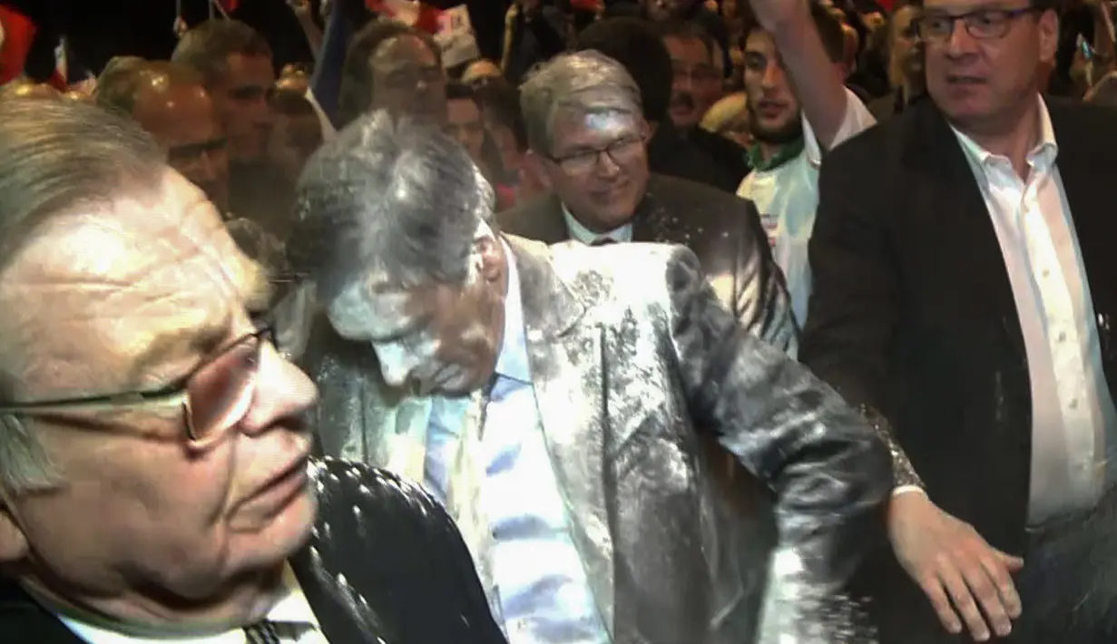Kandidat Presiden Prancis, Francois Fillon menuju ruang ganti setelah dilempar tepung di sebuah acara kampanye di Prancis Timur, Kamis (6/4). Fillon tengah berada di kerumunan orang ketika seorang pria melemparkan tepung ke wajahnya. (JULIEN SENGEL/AFP)