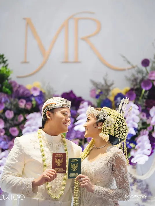 Keduanya tampak bertukar senyum saat memamerkan buku pernikahan ke hadapan kamera. (Foto: Instagram/ axioo)