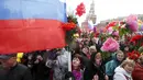 Puluhan orang berjalan sambil membawa bendera dan bunga plastik saat peringatan Hari Buruh Internasional (May Day) di Red Square, Moskow, Jumat (1/5/2015). (REUTERS/Maxim Zmeyev)